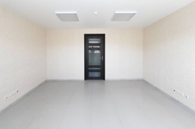 Yeni bir binada mobilyasız beyaz duvar kağıdı ile iç boş ofis ışık Oda