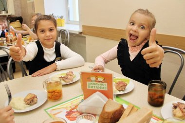Komik, güleryüzlü öğrenciler oturmuş, tablo içinde okul kafeterya yemek yemek grubu. içme suyu-Rusya, Moskova, ilk yüksek okulu, birinci sınıf b - 30 Eylül 2018