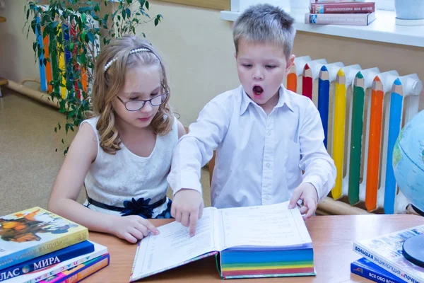 两个小学童 男孩和女孩坐在教室的桌子旁 阅读学习书 俄罗斯 莫斯科 第一所高中 2018年10月28日 — 图库照片