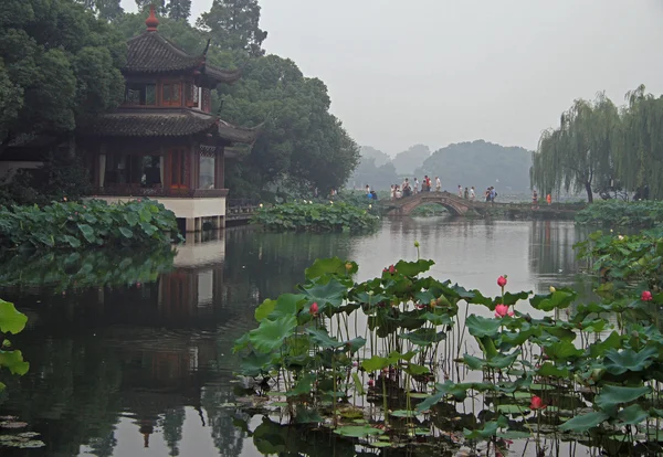 Mensen zijn het overschrijden van het west lake in Hangzhou met brug — Stockfoto