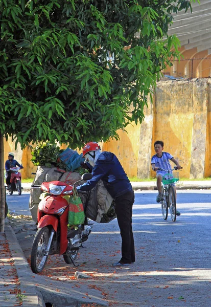 Túlterhelt robogó ember ellenőrzi a kültéri kerékpáros — Stock Fotó
