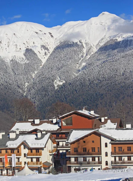Aldeia hoteleira na estância de esqui, montanhas caucasianas nevadas — Fotografia de Stock