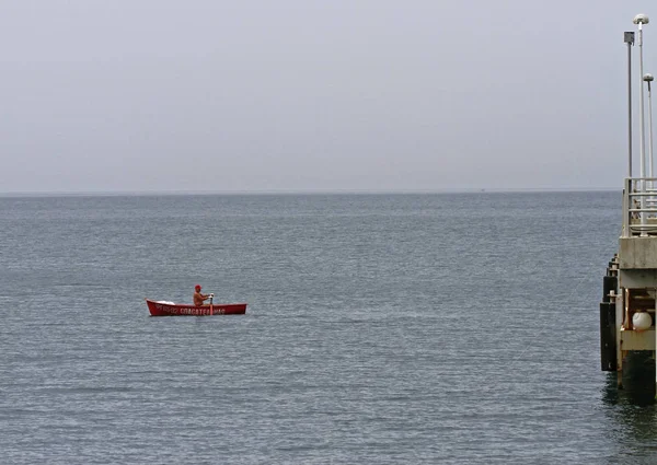 Mann in Rettungsboot patrouilliert am Meer — Stockfoto