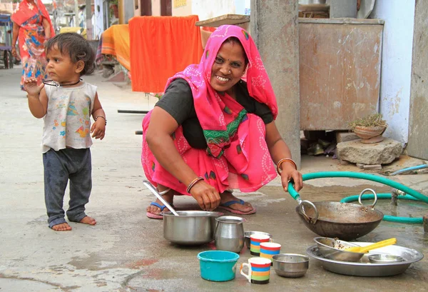 Mujer está lavando platos al aire libre en Jaipur, India — Foto de Stock