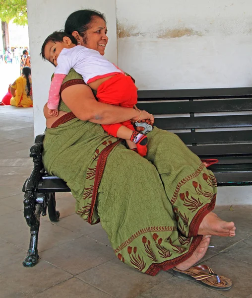 Kadın oğluyla bir bankta oturan — Stok fotoğraf