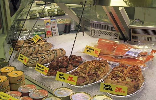 Puesto con pequeños pasteles y pescado en el mercado —  Fotos de Stock