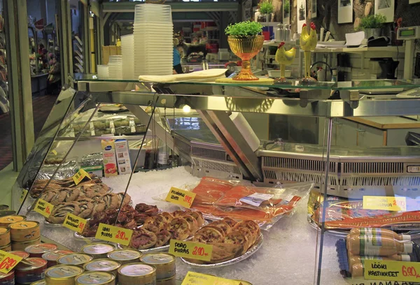 Puesto con pequeños pasteles y pescado en el mercado —  Fotos de Stock