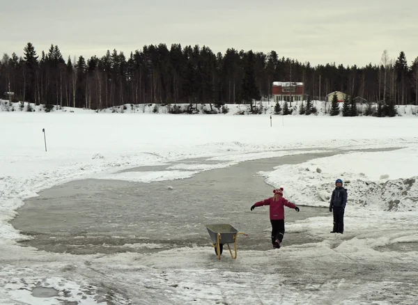 Barn leker med snö på frusna floden i Rovaniemi, Finland — Stockfoto