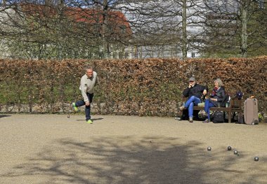men are playing petanque outdoor in public park, Copenhagen clipart