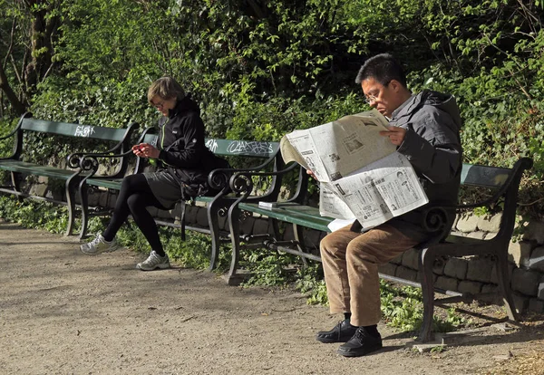 Двое сидят на скамейках в общественном парке Копенгагена — стоковое фото