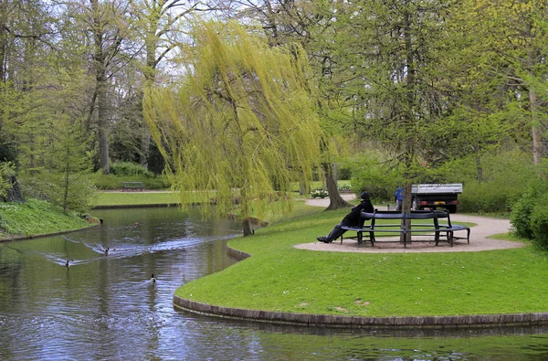 Vecchio è seduto su una panchina nel parco — Foto Stock