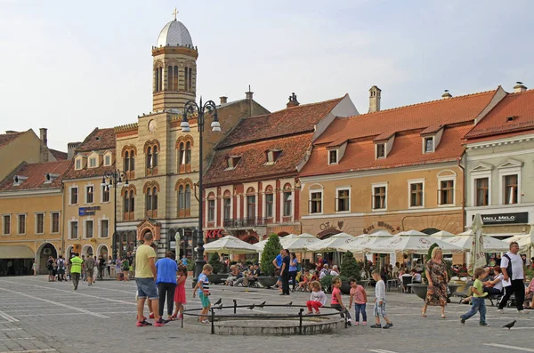 La gente cammina vicino alla piazza del consiglio a Brasov, Romania — Foto Stock
