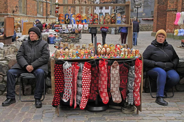 Hombre y mujer están vendiendo recuerdos y ropa de abrigo al aire libre —  Fotos de Stock