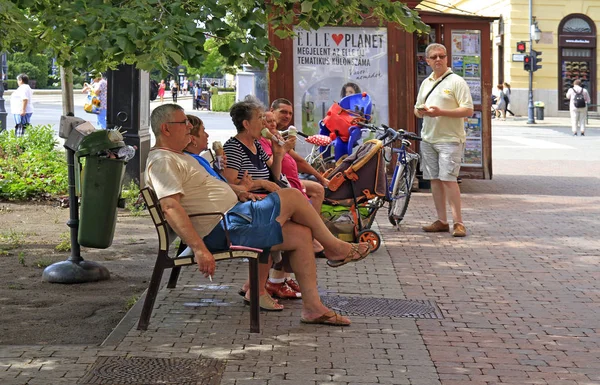 Människor vilar på en bänk ute i Debrecen, Ungern — Stockfoto