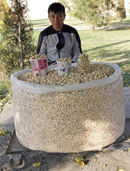 Hombre vendiendo palomitas de maíz dulce uzbeko al aire libre en Samarcanda —  Fotos de Stock