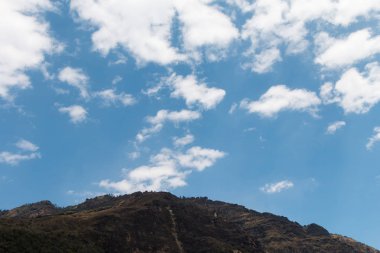 üstte dağ manzaralı bulutlu mavi gökyüzü