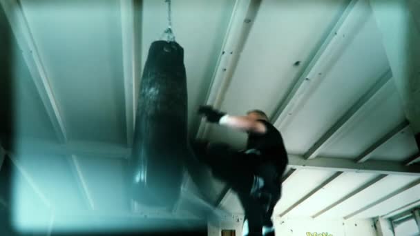 Male Athlete boxer punching bag with dramatic edgy lighting in a dark studio — Stock Video