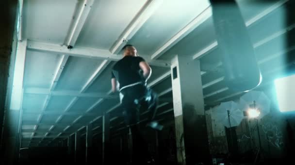 극적인 초 초 조명 어두운 스튜디오에서 남성 선수 복 서 펀치 백 — 비디오