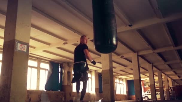 Worek treningowy mężczyzna sportowiec bokser z dramatyczne kanciasty oświetlenia w ciemnych studio — Wideo stockowe