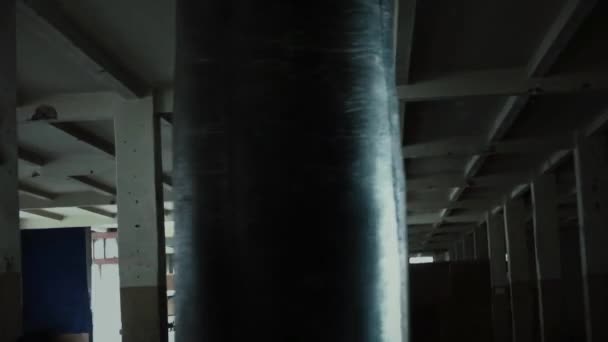 Hombre atleta boxeador saco de boxeo con iluminación de borde dramático en un estudio oscuro — Vídeo de stock