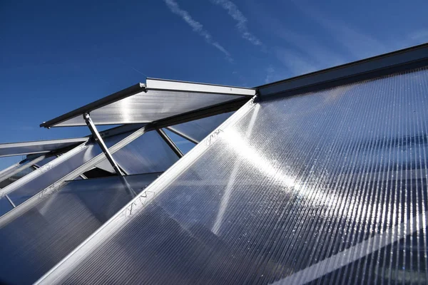 Close-up do complexo de estufa moderno contra o céu azul. visão de ângulo largo . — Fotografia de Stock