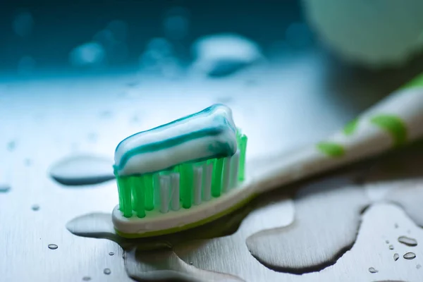 Escova de dentes e pasta de dentes no fundo desfocado — Fotografia de Stock