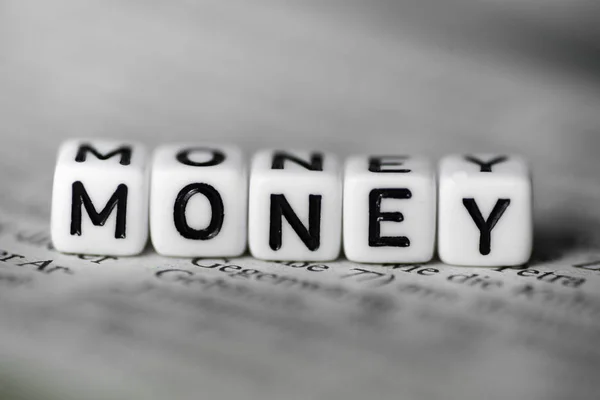 Word MONEY formed by wood alphabet blocks on newspaper — Stock Photo, Image