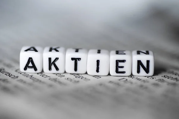 德国词 Aktien 由木头字母块形成在报纸 — 图库照片