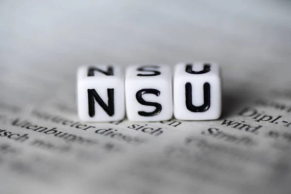 German Word NSU formed by wood alphabet blocks on newspaper — Stock Photo, Image