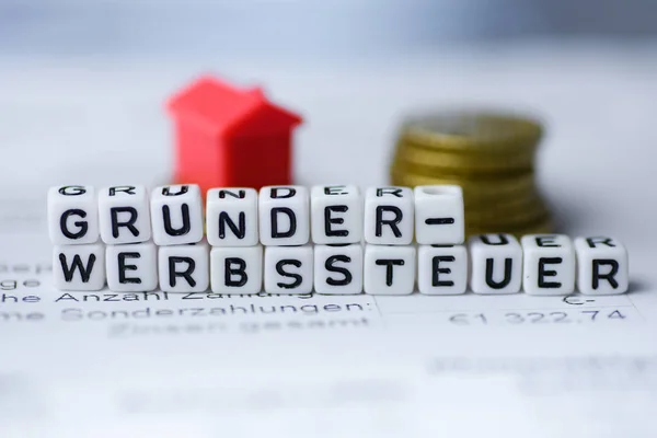 German Word REAL ESTATE TAXES formed by alphabet blocks: GRUNDERWERBSSTEUER