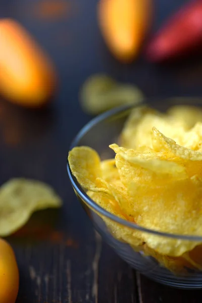 Potatischips med paprika på mörk trä bakgrund — Stockfoto