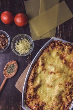 Lazanya hizmet taze domates ile ahşap bir tahta üzerinde katmanlı