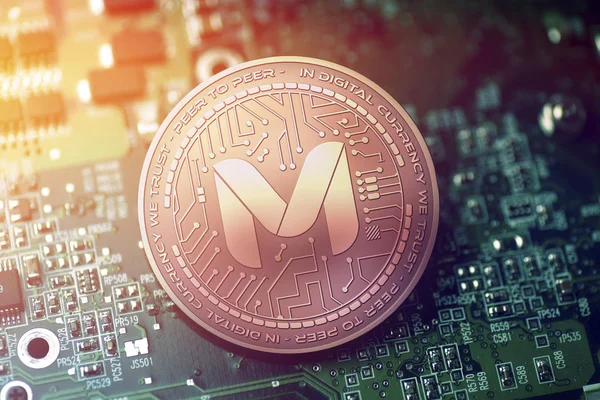 shiny copper MONETHA cryptocurrency coin on blurry motherboard background