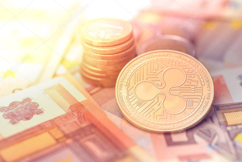shiny golden RIPPLE cryptocurrency coin on blurry background with euro money