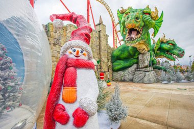 Sochi, Rusya-20.09.2018 Sochi Parkı. Girişteki Noel ağacı. Beyaz kardan adam. Kırmızı şapka. Kırmızı eşarp. Burun havuçtur..