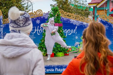Sochi, Rusya-20.09.2018 Sochi Parkı. Girişteki Noel ağacı. Beyaz kardan adam. Kırmızı şapka. Kırmızı eşarp. Burun havuçtur..