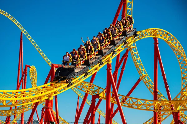 Sochi, Rusia-20.12.2018 Montaña rusa. Parque de atracciones y entretenimiento. Adrenalina, diversión, construcción de metal. Sochi Park. Los soportes metálicos amarillos. Clima despejado, cielo azul. Caras felices gente —  Fotos de Stock