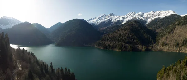 Fotografía aérea de un cuadrocoptero. Lago Ritsa. Montaña Abjasia. Atracción del país. Montañas nevadas. Cielo azul claro. No hay gente. Turismo y recreación al aire libre. Reserva. Altura —  Fotos de Stock