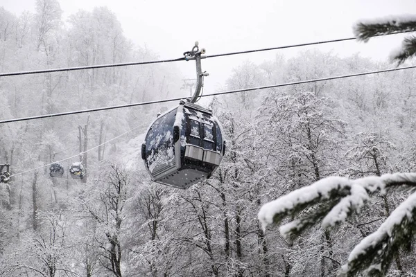 The cable car. Winter. White snow. Mountains. Rest in nature. Cloudy weather. No people. Trees in the snow.