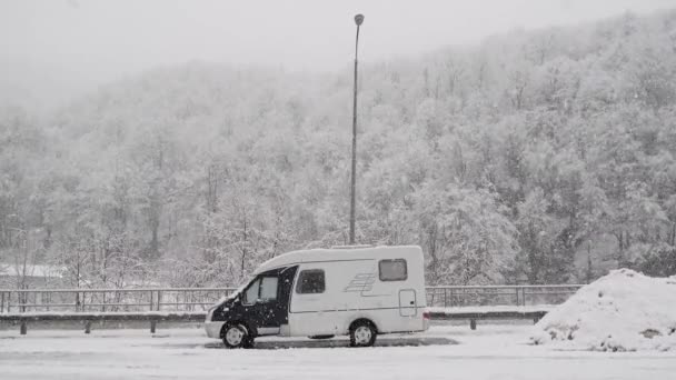 Egy lakókocsi az úton. Havazik. Lakókocsi. Van. Ez az év hideg időszaka. Nincsenek emberek. Pihenés a természetben. — Stock videók