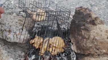 Spor giyimli genç bir adam ızgarada et pişiriyor. Huzur içinde yat. Ateşle. - Et. Yiyecekler. Bıçak. Açlık. Barbekü. Karavanda. Kampçı.. 