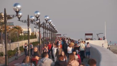 Sochi, Rusya - 12.03.2020 Gezinti Alanı. Birçok insan akşam yol boyunca yürür. Kalabalık. Akşam vakti. Tatil köyünde. Trafik vardı.