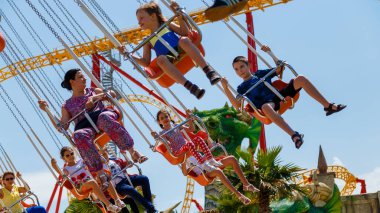 Sochi, Rusya - 05.06.2019 Çocuklar ve yetişkinler atlıkarıncaya biniyor. Eğlence parkı. Sochi Parkı. Parkta dinlen. Salla. Aile tatili. Eğlenceliydi. Tatil. 