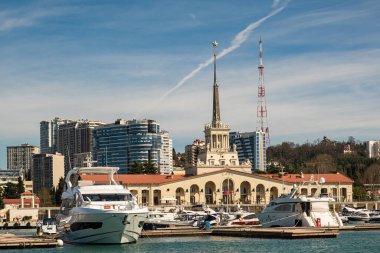Sochi, Rusya - 03.04.2020 Soçi Limanı. Yatlar ve gemiler limanda. Tarihi bir bina. Deniz kenarındaki yüksek modern evler. Güneşli bir gün.. 