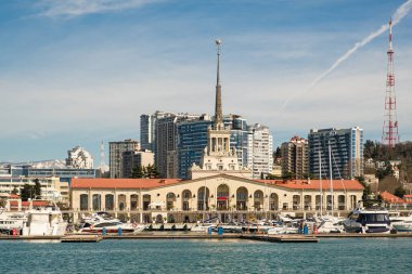 Sochi, Rusya - 03.04.2020 Soçi Limanı. Yatlar ve gemiler limanda. Tarihi bir bina. Deniz kenarındaki yüksek modern evler. Güneşli bir gün.. 