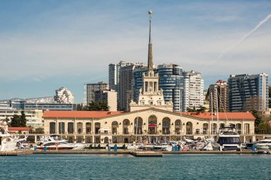 Sochi, Rusya - 03.04.2020 Soçi Limanı. Yatlar ve gemiler limanda. Tarihi bir bina. Deniz kenarındaki yüksek modern evler. Güneşli bir gün.. 