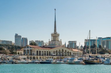 Sochi, Rusya - 04.04.2020 Yat ve Rusya 'nın Sochi limanındaki gemiler. Deniz manzarası. Şehrin merkezinde tarihi bir bina var. Yürüyen toprak seti. 