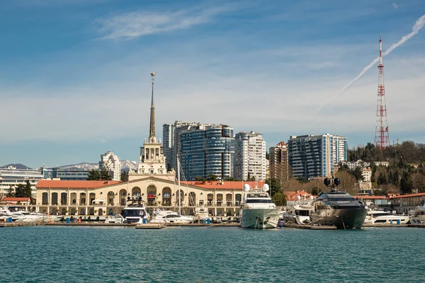 Sochi, Rusya - 03.04.2020 Soçi Limanı. Yatlar ve gemiler limanda. Tarihi bir bina. Deniz kenarındaki yüksek modern evler. Güneşli bir gün.. 