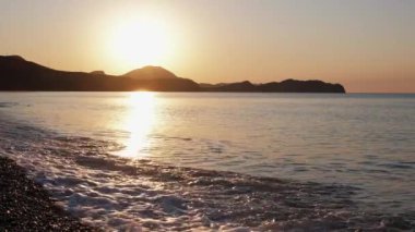 Denizin üzerinde gün doğumu. Hiç insan yok. - Günaydın. Gökyüzü açık. Ağır çekim. El salla. Gelgit.