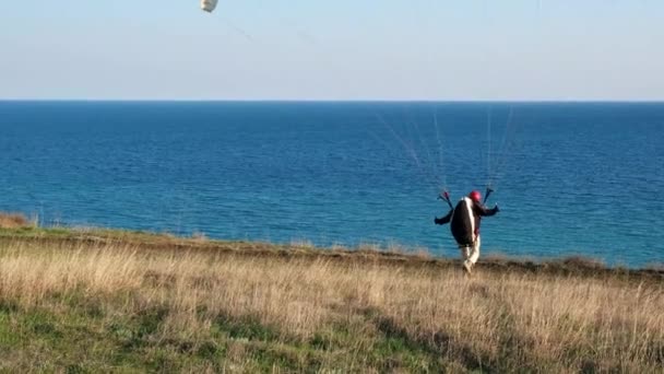 Sotsji. Rusland - 03.03.2020 vleugel van de paraglider. begint op te stijgen, breekt van de grond af. Langzame beweging — Stockvideo